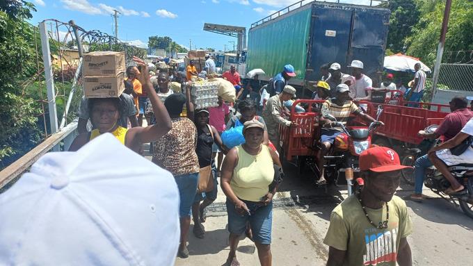 En medio de disturbios en su país, haitianos se abastecen de alimentos en Dajabón