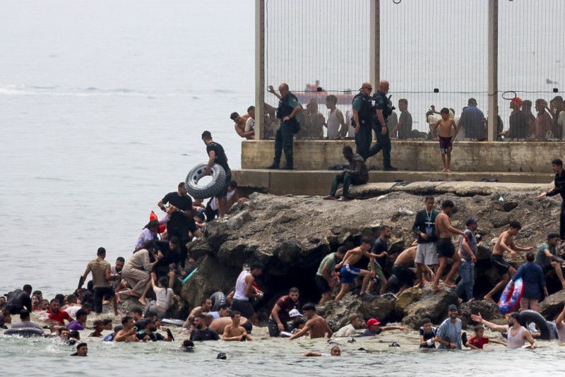 Miles de marroquíes cruzan la frontera en masa para entrar a España Miles de marroquíes cruzan la frontera en masa para entrar a España